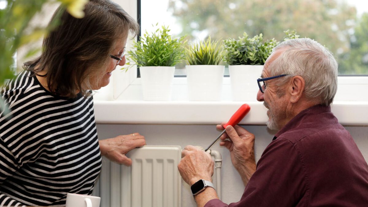 Mann zeigt Frau wie eine Heizung repariert wird
