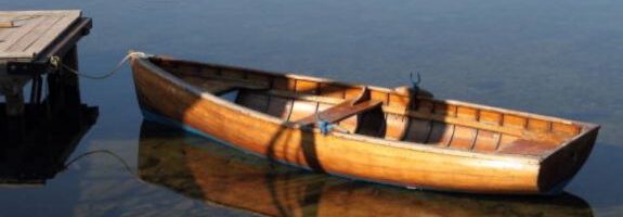 Ein hölzernes Ruderboot liegt an einem kleinen Steg auf klarem, ruhigem Wasser. Die Spiegelung des Boots ist im Wasser sichtbar. Unten rechts befindet sich das MEET CAMPUS Logo mit geometrischem Design. Ein hölzernes Ruderboot liegt an einem kleinen Steg auf klarem, ruhigem Wasser. Die Spiegelung des Boots ist im Wasser sichtbar. Unten rechts befindet sich das MEET CAMPUS Logo mit geometrischem Design.