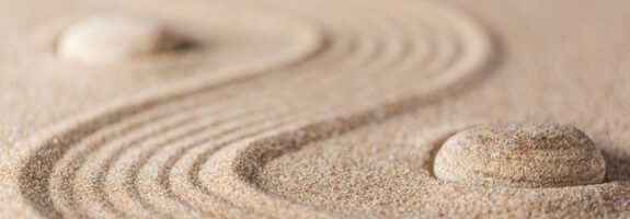 Spuren im Sand mit Steinen, die wie ein Weg aussehen